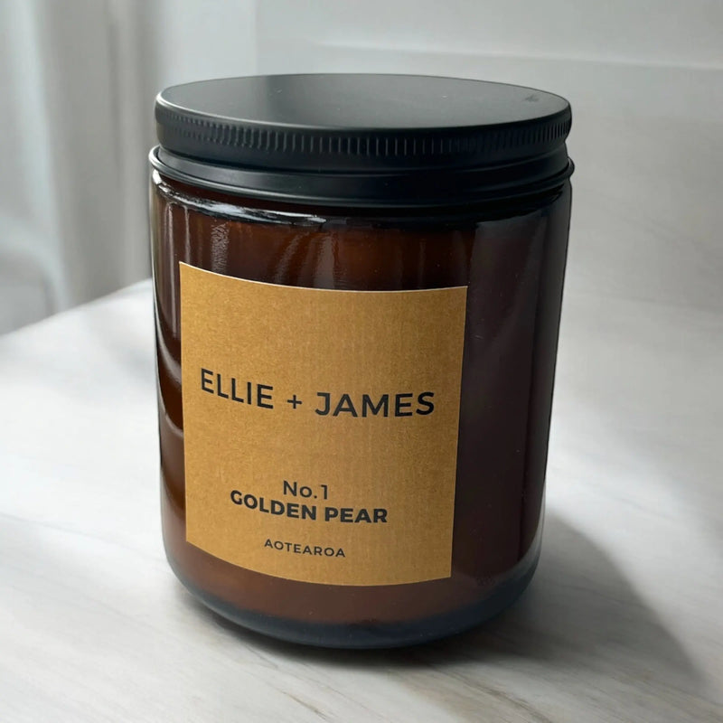 Jar of 'No.1 Golden Pear' candle by Ellie + James on a white surface