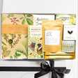 Gift set with products including a notebook, chocolate, and bath products on a white background.