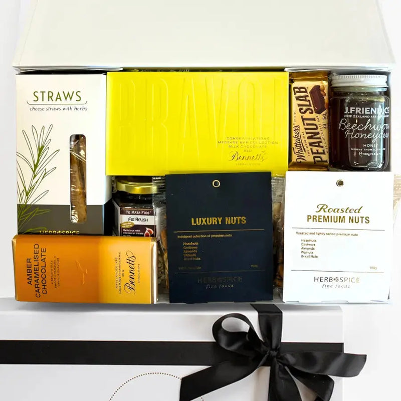 Assorted snacks and treats in a box with a black ribbon