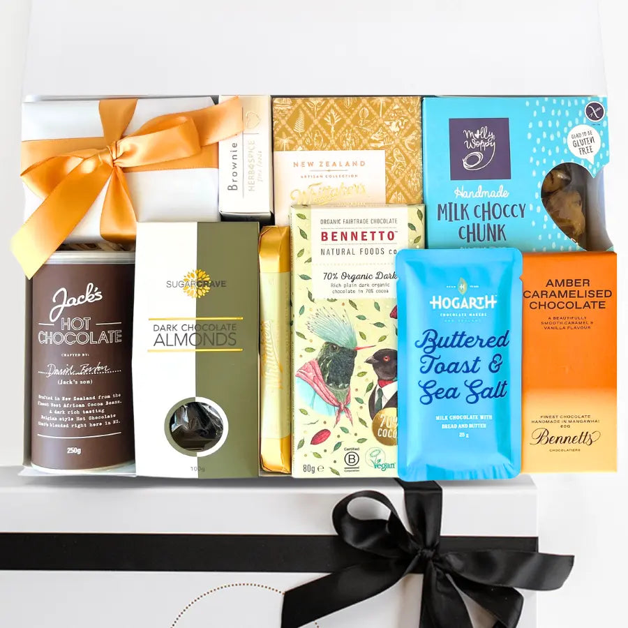 Assorted chocolate products including a jar of hot chocolate, a box of dark chocolate almonds, and various chocolate bars with visible branding.