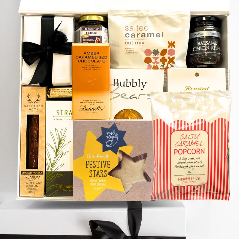 Gift box with various snacks and treats including chocolate, popcorn, and cookies.