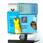 Assorted chocolate and cookie products with a yellow bunny-shaped tool on a white background