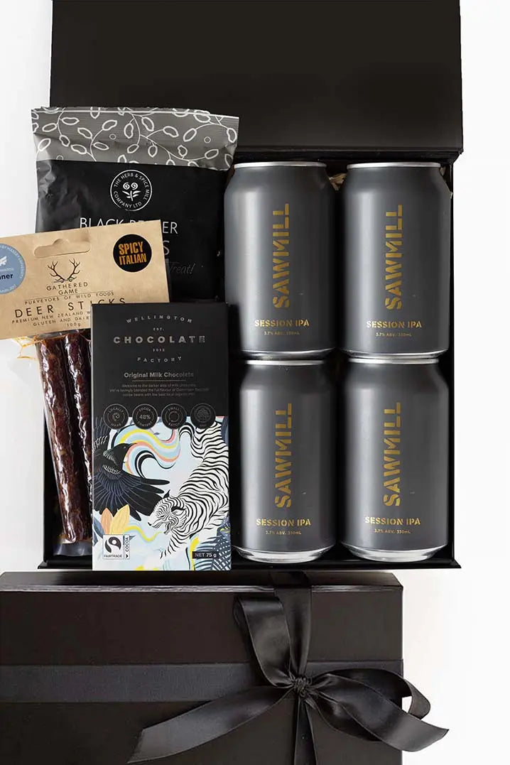 Gift set with Sawmill beer cans, chocolate bar, and other items in a black box.