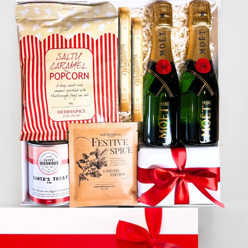 Gift set with Moët champagne, popcorn, and festive spice mix on a white background