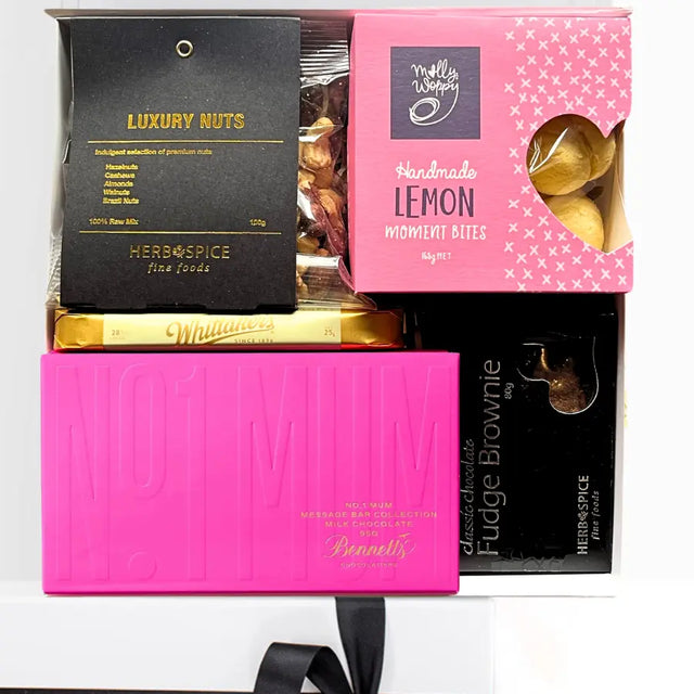 Assorted gourmet treats in a box with nuts, chocolate and lemon bites.