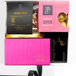 Assorted gourmet treats in a box with nuts, chocolate and lemon bites.