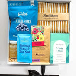Assorted products including blueberries, buttered toast, sea salt, and a towel in a box.