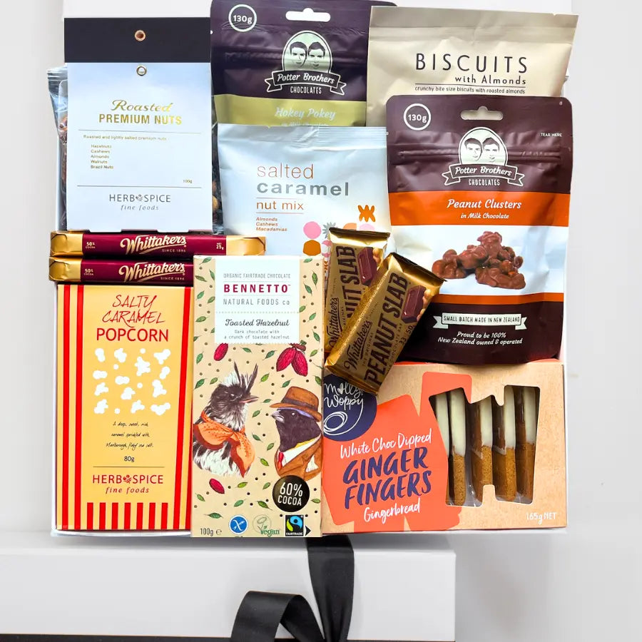 Assorted snack packages including biscuits, popcorn, and ginger fingers on a white background