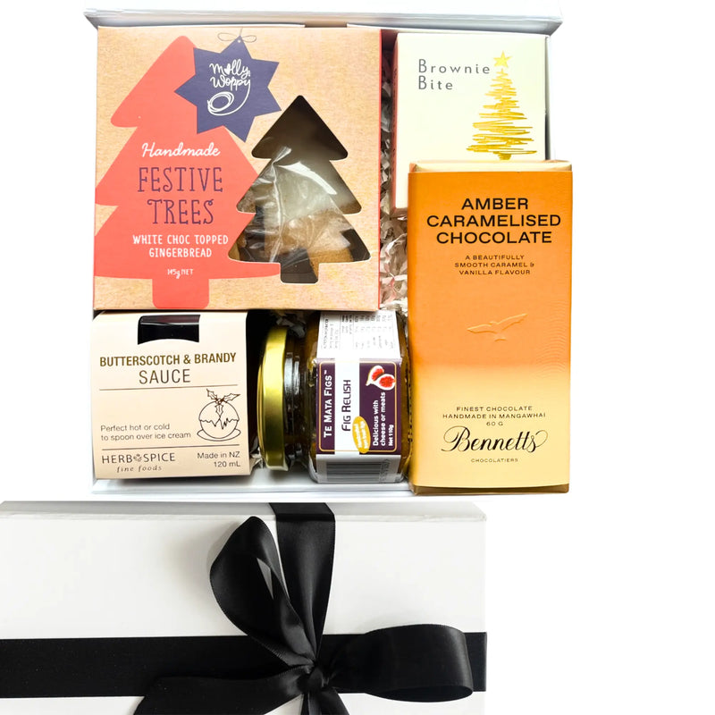 Gift set with festive tree packaging, chocolate, and other items on a white background