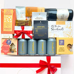 Gift basket with wine, snacks, and beer cans on a white background