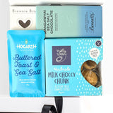 Assorted chocolate products including a blue packet of 'Buttered Toast & Sea Salt' and a box of 'Milk Choccy Chunk'.