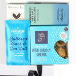 Assorted chocolate products including a blue packet of 'Buttered Toast & Sea Salt' and a box of 'Milk Choccy Chunk'.