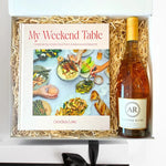 Gift set with a cookbook and a bottle of wine in a box.