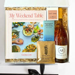 Gift box with a cookbook, wine, and other items on a white background