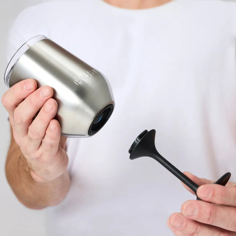 Person holding a stainless steel wine tumbler.