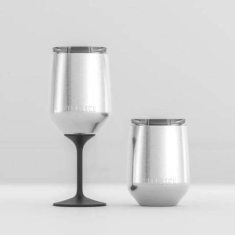 Two stainless steel tumblers with black stems on a light gray background
