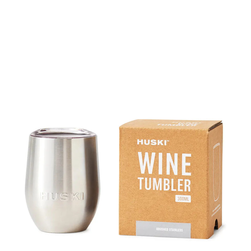 Silver wine tumbler next to its packaging box on a white background